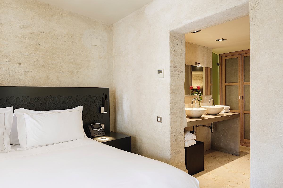 Bed and bathroom of the Junior Suite Views at the EME Catedral Mercer