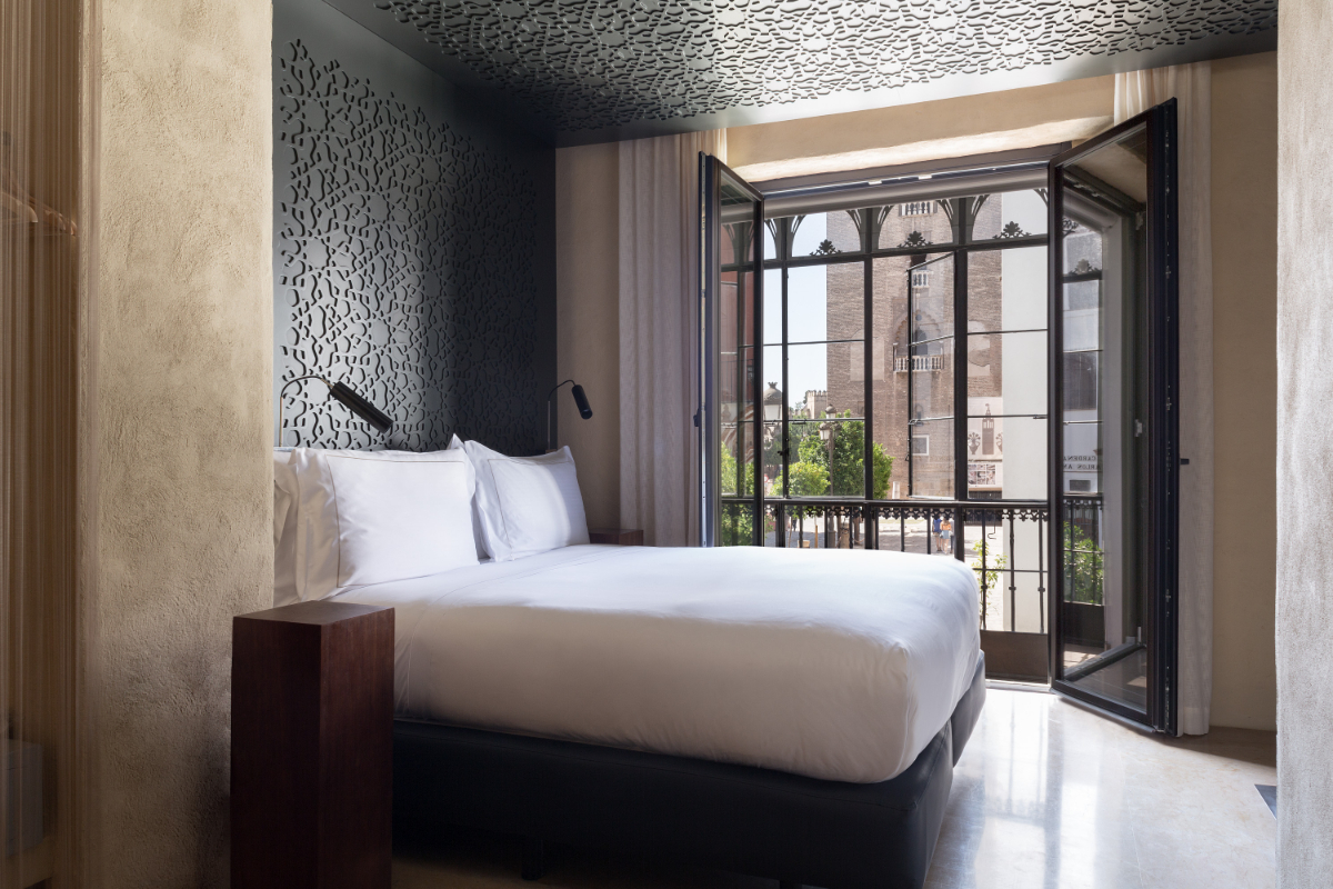 Bed and balcony of the Grand Deluxe Views at the EME Catedral Mercer