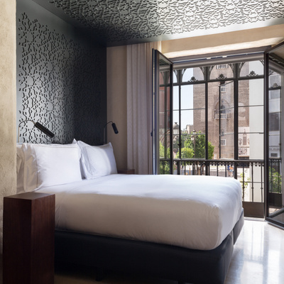 Bed and balcony of the Grand Deluxe Views at the EME Catedral Mercer