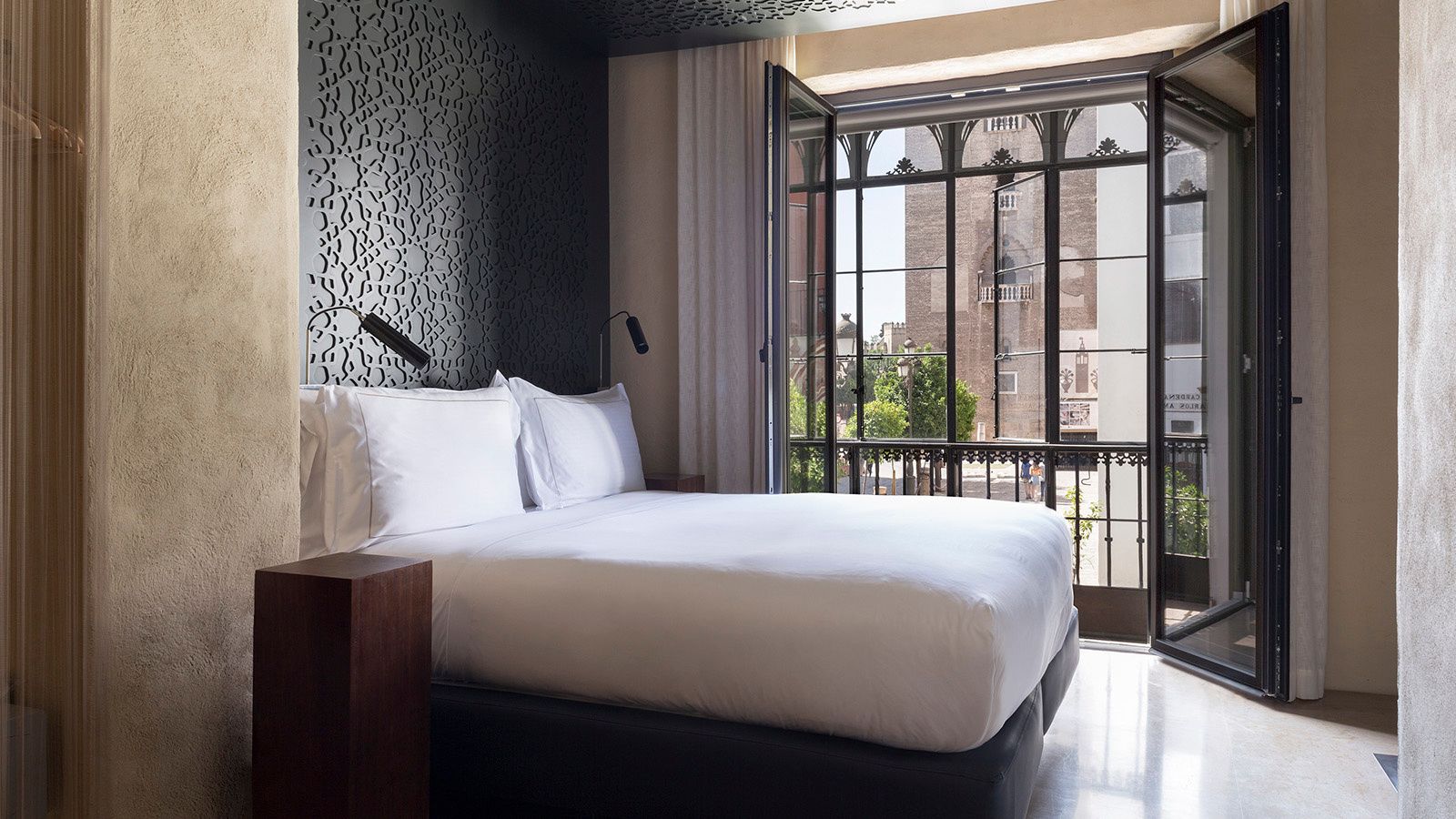 Bed and balcony of the Grand Deluxe Views at the EME Catedral Mercer