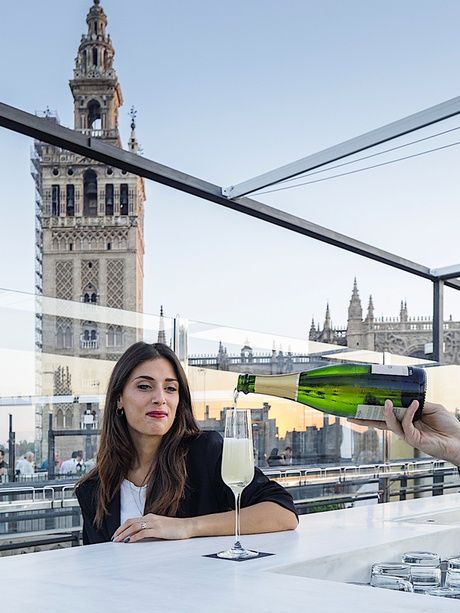 fille ayant un verre de cava sur la terrasse de l'EME avec vue sur la cathédrale de Séville